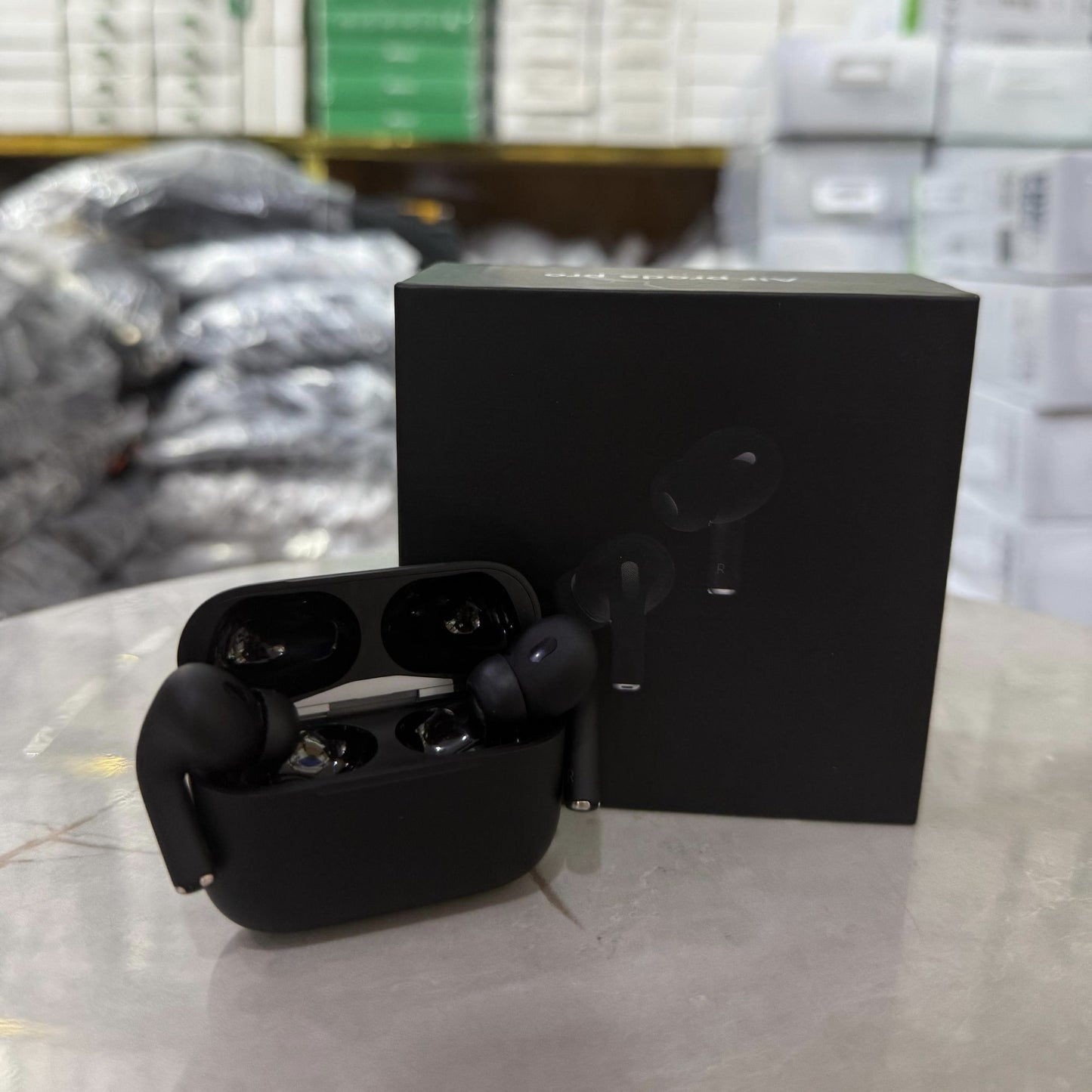 Matte black AirPods Pro-style wireless earbuds with active noise cancellation, displayed in an open charging case alongside a sleek black packaging box. The earbuds have a premium finish, making them a stylish choice for high-quality Bluetooth audio. Perf